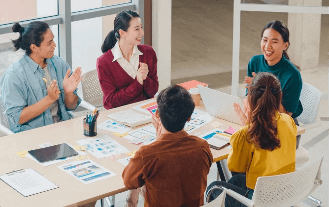 people at the meeting laughing to each other